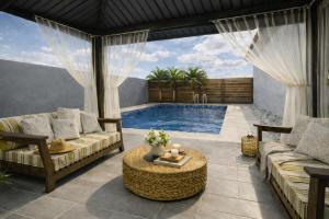 a living room with a pool and a couch and a table at Solito 52 in Oranjestad