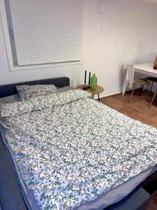 a bed with a flowered comforter in a bedroom at Cozy apartment in Drammen