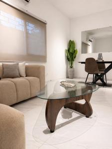 a living room with a glass table and a couch at Silver Apartment Abidjan in Abidjan +3 photos