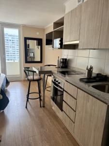a kitchen with a counter and a table and chairs at Alto Arrayán in Osorno