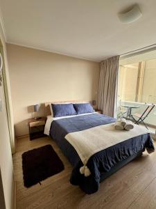 a bedroom with a large bed with blue pillows at Alto Arrayán in Osorno