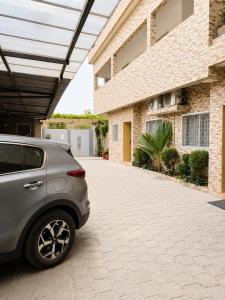 a car parked in a driveway in front of a building at Silver Apartment Abidjan in Abidjan