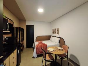 a bedroom with a bed and a table with chairs at One Studios Indaiatuba in Indaiatuba