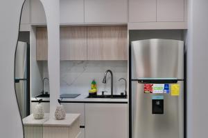 a kitchen with a stainless steel refrigerator and a sink at Cielo Apartments with top amenities in Quito