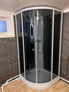 a shower with a glass door in a bathroom at Cozy apartment in Drammen