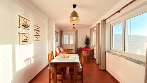 a dining room with a table and a window at Apartamento sto estavão 2 in Zambujeira do Mar