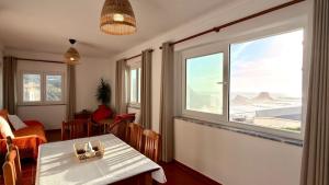 a dining room with a table and a window at Apartamento sto estavão 2 in Zambujeira do Mar