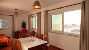 a dining room with a table and a window at Apartamento sto estavão 2 in Zambujeira do Mar