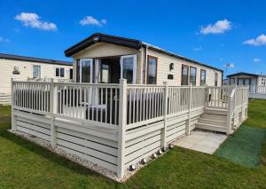 a mobile home with a white fence at Aurora Beacon View in Lossiemouth +11 photos