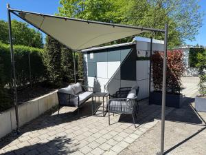 a canopy over a patio with two chairs and a table at Residence Loft in Friedrichshafen