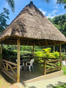 a wooden gazebo with a table and chairs at St. Patrick’s Forest House in Entebbe
