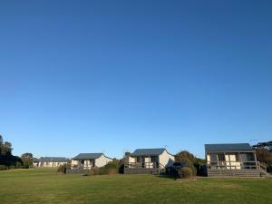 a row of houses on a green field at Prom Gate Getaway in Yanakie