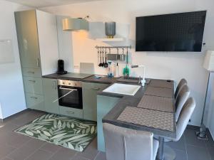 a kitchen with a counter with a sink and a stove at Traum Ferienwohnung Kell am See in Kell +6 photos
