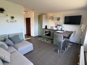 a living room with a couch and a kitchen with a table at Traum Ferienwohnung Kell am See in Kell