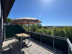 a patio with a table and an umbrella at Traum Ferienwohnung Kell am See in Kell