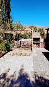 a wooden arch with a fence in a yard at Misky Sonqo in Tilcara