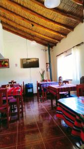 a restaurant with tables and chairs and a flat screen tv at Misky Sonqo in Tilcara +17 photos