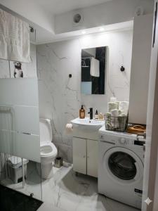 a white bathroom with a washing machine and a sink at Dimi Deluxe in Perea +21 photos