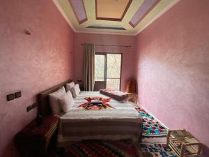 a bedroom with a large bed with pink walls at imlil in Imlil