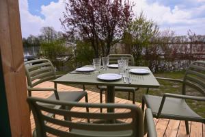 a table with chairs and plates and glasses on it at Tiny House Nook 1 - Green&Tiny Hideaway Eider in Süderstapel