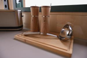 a wooden cutting board with two spoons and a mirror at Tiny House Nook 1 - Green&Tiny Hideaway Eider in Süderstapel