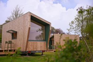 a tiny house on a trailer with a large window at Tiny House Nook 2 - Green&Tiny Hideaway Eider in Süderstapel