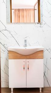 a bathroom with a white sink and a mirror at Arditis Cozy Studio in Bogë