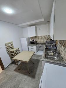 a small kitchen with a sink and a table at Appartement Jasmin in Gabès