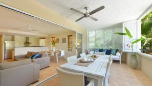 a living room with a table and a dining room at Cayman Villas Port Douglas in Port Douglas