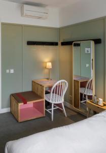 
a bedroom with a bed, chair, desk and a lamp at Hotel Light in Rotterdam
