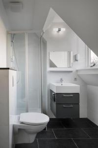 a white bathroom with a toilet and a sink at Hotel Light in Rotterdam
