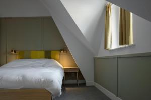 ein Schlafzimmer mit einem weißen Bett und einem Fenster in der Unterkunft Hotel Light in Rotterdam