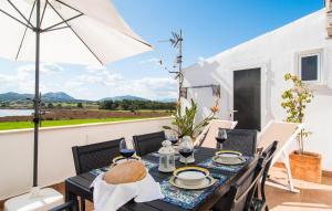 a dining room with a table and chairs and an umbrella at Sa Fornera in Alcudia