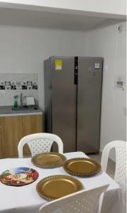 a kitchen with a table with plates and a refrigerator at Tangará real 204 in Apulo