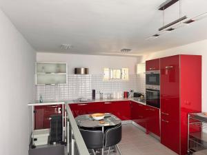 a kitchen with red cabinets and a table in it at Casa De Pablo - Marbella Golf in Maspalomas