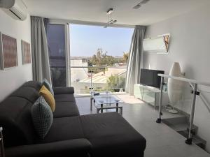 a living room with a couch and a large window at Casa De Pablo - Marbella Golf in Maspalomas