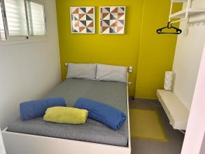 a bedroom with a bed with a yellow and blue pillow at Casa De Pablo - Marbella Golf in Maspalomas +17 photos