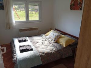 a small bed in a room with a window at Vila Jezerce Zlatibor Zbojštica in Užice