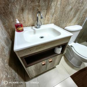 a bathroom with a sink and a toilet at Apt 08, aconchegante e prático, para sua estadia in Igrejinha +28 photos