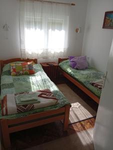 two beds sitting in a room with a window at Vila Jezerce Zlatibor Zbojštica in Užice