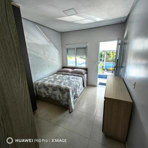 a bedroom with a bed and a table in it at Apt 08, aconchegante e prático, para sua estadia in Igrejinha