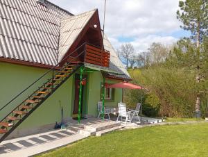a small green house with a staircase and a table and chairs at Vila Jezerce Zlatibor Zbojštica in Užice