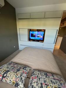 a bedroom with a bed and a tv on a wall at Mono Ambiente Con Vista Panorámica Zona Sur in Santiago del Estero
