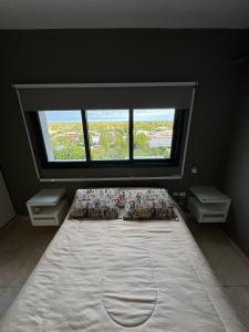 a large bed in a room with a large window at Mono Ambiente Con Vista Panorámica Zona Sur in Santiago del Estero +9 photos