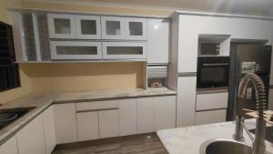 a kitchen with white cabinets and a sink at Hyponia 1512 in Oshikuku