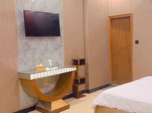 a hotel room with a tv on a wall at Sapphire Guest House in Karachi