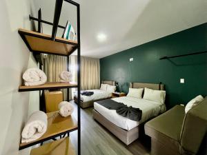 a bedroom with two beds and a green wall at Jazz & Stay in Guadalajara