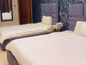 two beds sitting next to each other in a room at Sapphire Guest House in Karachi