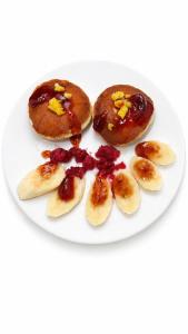 a plate with three donuts with peanut butter and banana slices at Halqyma Hotel in Oral