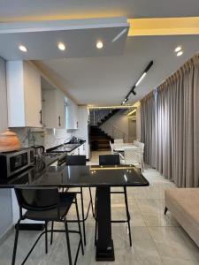 a kitchen and living room with a table and chairs at Masa villa in Ash Shāghūr